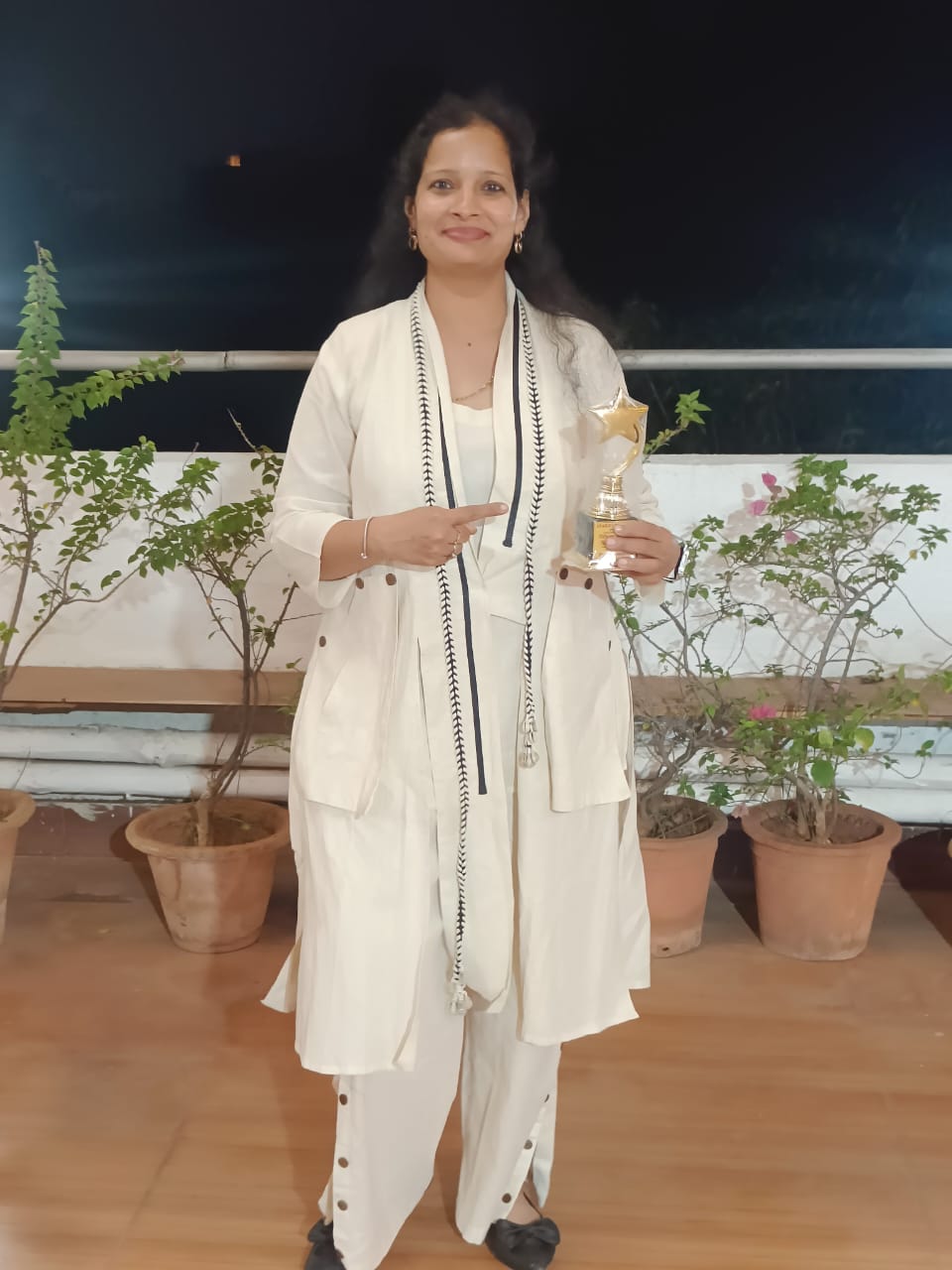 Jyoti Maheswari holding a star-shaped award trophy